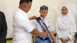 
Ketua Bawaslu Pessel, Afriki Musmaidi memasangkan selempang kepada Aliffran Gunawan dan Arini Soleha saat dinobatkan sebagai Duta Informasi PPID. (Foto: Dok Humas Bawaslu)
