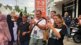 Wisatawan asing mengabadikan momen di Karnaval Kota Tua, Kamis (7/8/2025). (Foto: Diskominfo Padang)