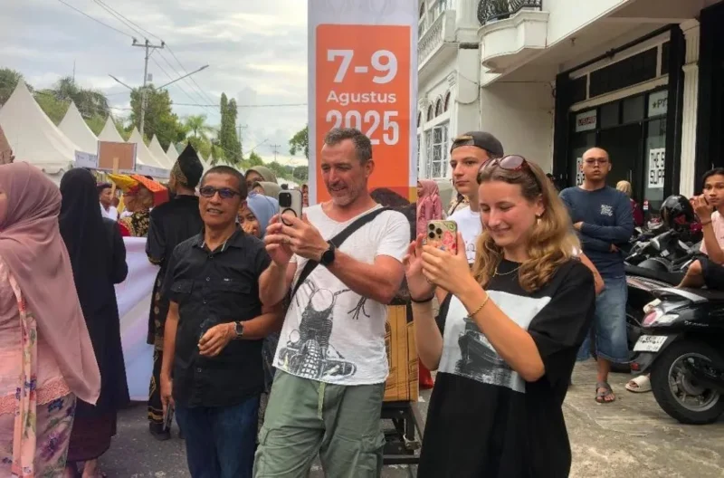 Wisatawan asing mengabadikan momen di Karnaval Kota Tua, Kamis (7/8/2025). (Foto: Diskominfo Padang)
