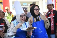 Sesmen Ekraf/Bekraf RI, Dessy Ruhati mencicipi rendang yang dimasak di Sentra Rendang, Sabtu (9/8/2025). (Foto: Diskominfo Padang)