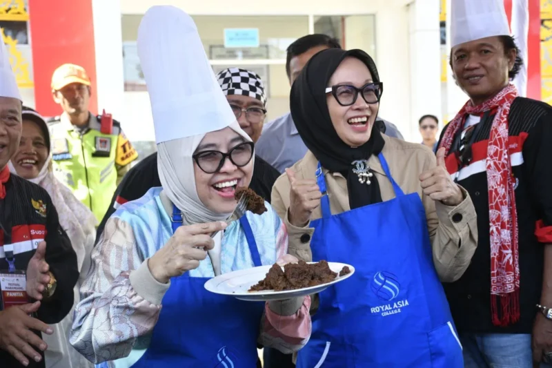 Sesmen Ekraf/Bekraf RI, Dessy Ruhati mencicipi rendang yang dimasak di Sentra Rendang, Sabtu (9/8/2025). (Foto: Diskominfo Padang)