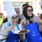 Sesmen Ekraf/Bekraf RI, Dessy Ruhati mencicipi rendang yang dimasak di Sentra Rendang, Sabtu (9/8/2025). (Foto: Diskominfo Padang)