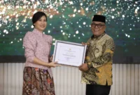 Bupati Pasbar Yulianto menerima penghargaan dari Wakil Menteri PPPA, Veronica Tan, Jumat (8/8/2025) malam. (Foto: Diskominfo Pasbar)