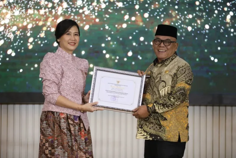 Bupati Pasbar Yulianto menerima penghargaan dari Wakil Menteri PPPA, Veronica Tan, Jumat (8/8/2025) malam. (Foto: Diskominfo Pasbar)