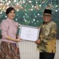 Bupati Pasbar Yulianto menerima penghargaan dari Wakil Menteri PPPA, Veronica Tan, Jumat (8/8/2025) malam. (Foto: Diskominfo Pasbar)