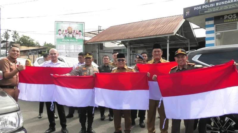 Bupati Pasbar, Yulianto, Wakil Bupati M. Ihpan, unsur Forkopimda, pejabat instansi vertikal dan OPD membagikan Bendera Merah Putih kepada Masyarakat, Senin (11/8/2025). (Foto: Diskominfo Pasbar)