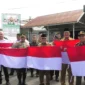 Bupati Pasbar, Yulianto, Wakil Bupati M. Ihpan, unsur Forkopimda, pejabat instansi vertikal dan OPD membagikan Bendera Merah Putih kepada Masyarakat, Senin (11/8/2025). (Foto: Diskominfo Pasbar)