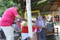 Wali Kota Pariaman Yota Balad membagikan Bendera Merah Putih kepada warga, Sabtu (9/8/2025). (Foto: Kominfo Pariaman)