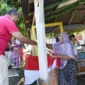 Wali Kota Pariaman Yota Balad membagikan Bendera Merah Putih kepada warga, Sabtu (9/8/2025). (Foto: Kominfo Pariaman)