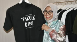 Sekretaris Menteri Ekraf/Bekraf RI, Dessy Ruhati memborong kaos hitam bertuliskan “Takuik Bini” yang terpajang di Galeri Dekranasda Padang, Sabtu (9/8/2025). (Foto: Diskominfo Padang)