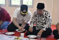 Presiden DMDI, Tun Seri Setia Dr. H. Mohd. Ali Bin Mohd. Rustam mencicipi rendang yang dimasak di Sentra Rendang, Sabtu (9/8/2025). (Foto: Diskominfo Padang) 