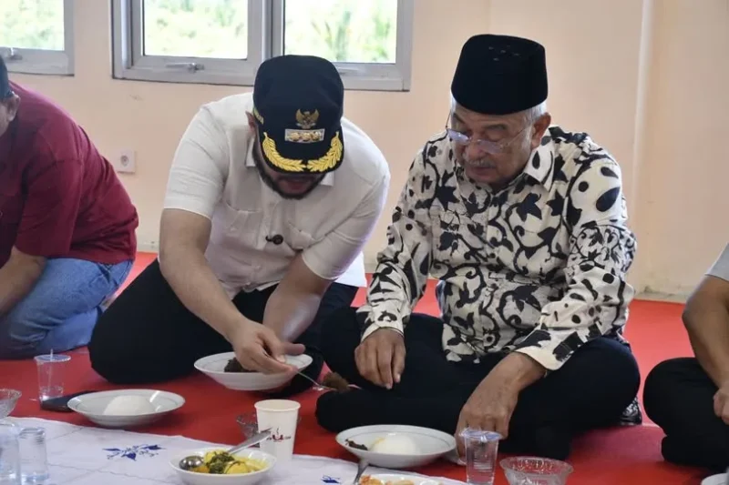 Presiden DMDI, Tun Seri Setia Dr. H. Mohd. Ali Bin Mohd. Rustam mencicipi rendang yang dimasak di Sentra Rendang, Sabtu (9/8/2025). (Foto: Diskominfo Padang) 