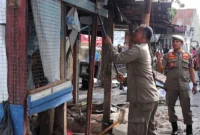 Petugas Satpol PP Padang membongkar bangli yang berdiri di atas fasum di Jalan Cendrawasih Patenggangan, Kamis (14/8/2025). (Foto: Humas Satpol PP Padang)