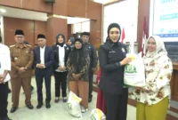 Anggota Komisi IV DPR RI, Cindy Monica Salsabila menyerahkan secara simbolis bantuan beras kepada warga di Aula Balai Kota Bukittinggi, Selasa (19/8/2025). (Foto: Pemko Bukittinggi)