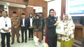 Anggota Komisi IV DPR RI, Cindy Monica Salsabila menyerahkan secara simbolis bantuan beras kepada warga di Aula Balai Kota Bukittinggi, Selasa (19/8/2025). (Foto: Pemko Bukittinggi)