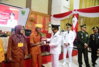 Bupati Padang Pariaman Dr. H. John Kenedy Azis menyerahkan tali asih kepada veteran yang tergabung dalam LVRI Padang Pariaman, Minggu (17/8/2025). (Foto: Kominfo Padang Pariaman) 