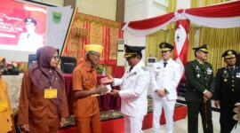 Bupati Padang Pariaman Dr. H. John Kenedy Azis menyerahkan tali asih kepada veteran yang tergabung dalam LVRI Padang Pariaman, Minggu (17/8/2025). (Foto: Kominfo Padang Pariaman) 