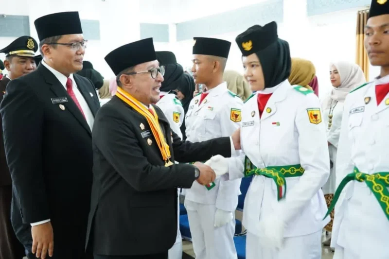 Bupati Tanah Datar Eka Putra menyalami anggota Paskibraka usai pengukuhan di Gedung Nasional Maharajo Dirajo, Sabtu (16/8/2025). (Foto: Prokopim Tanah Datar)