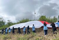 Sispala Boostra SMAN 2 Padang Panjang mengibarkan Bendera Merah Putih raksasa di Puncak Bukit Tui, Kelurahan Tanah Hitam, Kecamatan Padang Panjang Barat, Minggu (17/8/2025). (Foto: Kominfo Padang Panjang)