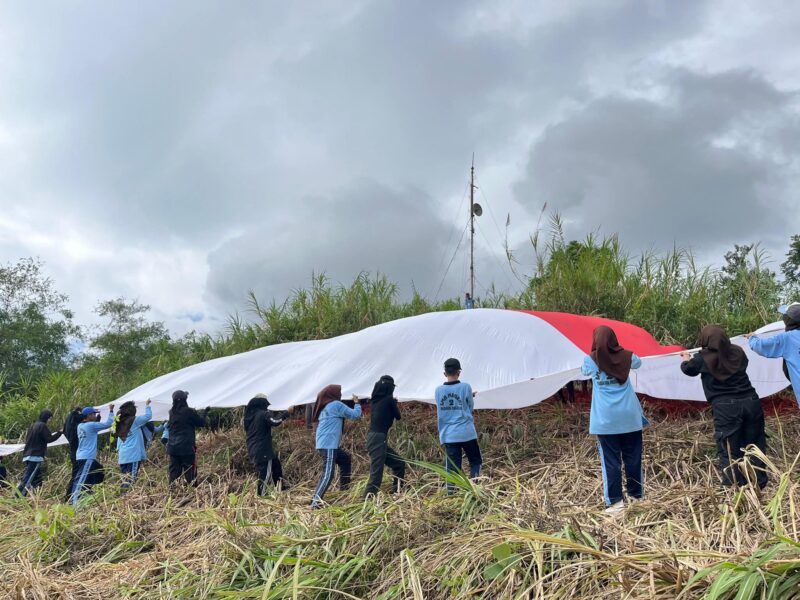 Sispala Boostra SMAN 2 Padang Panjang mengibarkan Bendera Merah Putih raksasa di Puncak Bukit Tui, Kelurahan Tanah Hitam, Kecamatan Padang Panjang Barat, Minggu (17/8/2025). (Foto: Kominfo Padang Panjang)