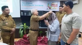 Staf Ahli Wali Kota Padang Bidang SDM dan Kemasyarakatan, Syahrial Kamat memasangkan kokarde kepada peserta pelatihan. (Foto: Diskominfo Padang)