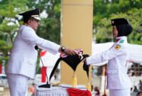 
Bupati Tanah Datar Eka Putra menyerahkan bendera Sang Merah Putih kepada anggota Paskibraka untuk dikibarkan pada upacara peringatan HUT ke-80 RI, Minggu (17/8/2025). (Foto: Prokopim Tanah Datar) 
