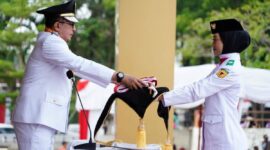 
Bupati Tanah Datar Eka Putra menyerahkan bendera Sang Merah Putih kepada anggota Paskibraka untuk dikibarkan pada upacara peringatan HUT ke-80 RI, Minggu (17/8/2025). (Foto: Prokopim Tanah Datar) 
