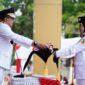 
Bupati Tanah Datar Eka Putra menyerahkan bendera Sang Merah Putih kepada anggota Paskibraka untuk dikibarkan pada upacara peringatan HUT ke-80 RI, Minggu (17/8/2025). (Foto: Prokopim Tanah Datar) 
