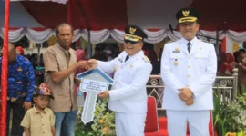 Bupati Pasbar Yulianto menyerahkan bantuan CSR perusahaan sawit kepada keluarga penerima manfaat, Minggu (17/8/2025). (Foto: Diskominfo Pasbar)