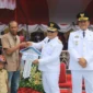 Bupati Pasbar Yulianto menyerahkan bantuan CSR perusahaan sawit kepada keluarga penerima manfaat, Minggu (17/8/2025). (Foto: Diskominfo Pasbar)
