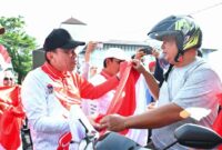 Wakil Wali Kota Padang Maigus Nasir membagikan Bendera Merah Putih kepada pengendara, Rabu (13/8/2025). (Foto: Prokopim Padang)