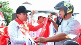Wakil Wali Kota Padang Maigus Nasir membagikan Bendera Merah Putih kepada pengendara, Rabu (13/8/2025). (Foto: Prokopim Padang)