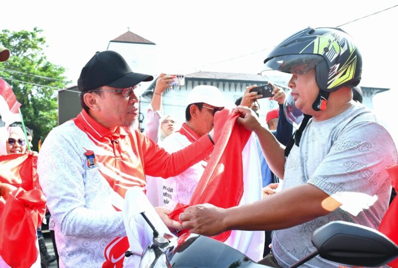 Wakil Wali Kota Padang Maigus Nasir membagikan Bendera Merah Putih kepada pengendara, Rabu (13/8/2025). (Foto: Prokopim Padang)