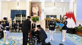 Presiden Prabowo berlutut mengalungkan Tanda Kehormatan Republik Indonesia berupa Bintang Jasa Utama kepada Teungku Nyak Sandang di Istana Negara, Jakarta, Senin (25/8/2025). (Foto: BPMI Setpres)  