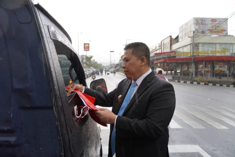 Wali Kota Padang Panjang Hendri Arnis membagikan Bendera Merah Putih kepada pengendara mobil, Jumat (15/8/2025). (Foto: Kominfo Padang Panjang)