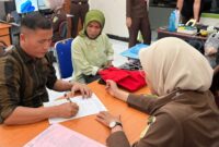 
Mantan Wali Nagari Sungai Nyalo IV Koto Mudiek, UA (kiri) saat menandatangani berkas tahap II (Foto: Dok Humas Kejari Pessel)