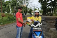 Tim SALIHA Kota Padang saat menyalurkan bantuan paket beras dari Anggota Komisi VIII DPR RI, Lisda Hendrajoni kepada salah satu driver ojol di Padang. (Foto: Dok. Tim SALIHA)