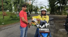 Tim SALIHA Kota Padang saat menyalurkan bantuan paket beras dari Anggota Komisi VIII DPR RI, Lisda Hendrajoni kepada salah satu driver ojol di Padang. (Foto: Dok. Tim SALIHA)