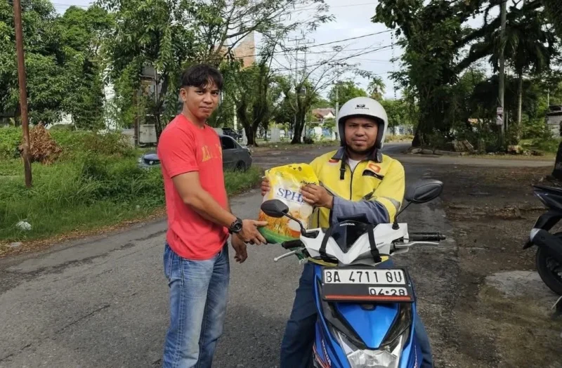 Tim SALIHA Kota Padang saat menyalurkan bantuan paket beras dari Anggota Komisi VIII DPR RI, Lisda Hendrajoni kepada salah satu driver ojol di Padang. (Foto: Dok. Tim SALIHA)