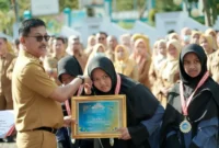 Bupati Solsel Khairunas memberikan penghargaan kepada pelajar yang sukses mengharumkan nama daerah di ajang Lomba Cerdas Quran Tingkat Sumbar 2025. (Foto: Humas Solsel)