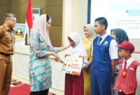 Bupati Dharmasraya, Annisa Suci Ramadhani menyerahkan Program Beasiswa Dharmasraya Juara 2025, Senin (29/9/2025). (Foto: Pemkab Dharmasraya)