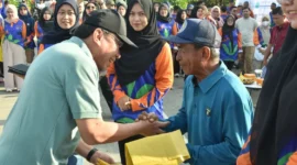 Wakil Wali Kota Padang Maigus Nasir menyerahkan secara simbolis kantong sampah kepada peserta gotong royong massal di Pantai Padang, Sabtu (20/9/2025). (Foto: Prokopim Padang)