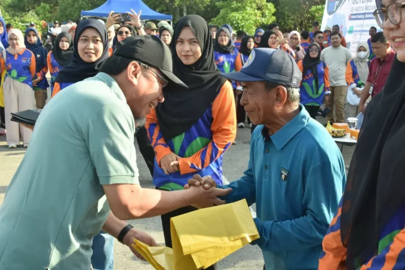 Wakil Wali Kota Padang Maigus Nasir menyerahkan secara simbolis kantong sampah kepada peserta gotong royong massal di Pantai Padang, Sabtu (20/9/2025). (Foto: Prokopim Padang)