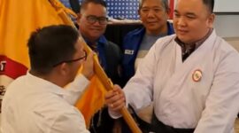 Ketua Pengprov Lemkari Sumbar periode 2025–2030, Nanda Satria menerima bendera saat pelantikan setelah terpilih sebagai ketua. (Foto: Dok. Gus)