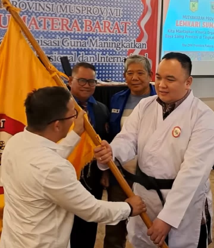 Ketua Pengprov Lemkari Sumbar periode 2025–2030, Nanda Satria menerima bendera saat pelantikan setelah terpilih sebagai ketua. (Foto: Dok. Gus)