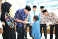 Wali Kota Pariaman Yota Balad menyerahkan infak GTK kepada murid SD kurang mampu, Jumat (12/9). (Foto: Kominfo Pariaman)