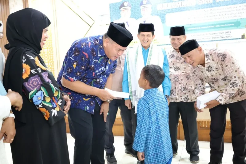 Wali Kota Pariaman Yota Balad menyerahkan infak GTK kepada murid SD kurang mampu, Jumat (12/9). (Foto: Kominfo Pariaman)