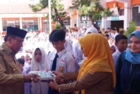 Wakil Wali Kota Padang, Maigus Nasir menyerahkan MBG kepada siswa di SMPN 30 Padang, Senin (15/9/2025). (Foto: Diskominfo Padang)