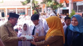 Wakil Wali Kota Padang, Maigus Nasir menyerahkan MBG kepada siswa di SMPN 30 Padang, Senin (15/9/2025). (Foto: Diskominfo Padang)