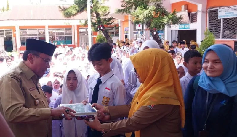 Wakil Wali Kota Padang, Maigus Nasir menyerahkan MBG kepada siswa di SMPN 30 Padang, Senin (15/9/2025). (Foto: Diskominfo Padang)